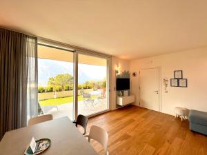 a living room with a dining table and a large window at Due Lune Home in Malcesine