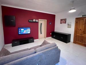 - un salon avec un canapé et une télévision dans l'établissement Merhba Apartment, à San Pawl il-Baħar