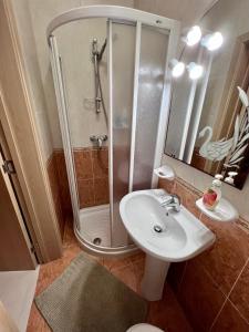 La salle de bains est pourvue d'une douche et d'un lavabo blanc. dans l'établissement Merhba Apartment, à San Pawl il-Baħar