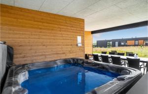 a hot tub in a patio with a wooden wall at Stunning Home In Lgstrup With Wifi in Løgstrup