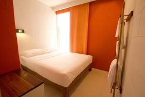 a small bed in a room with a window at Lantern Hotel in Kuala Lumpur