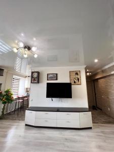 uma sala de estar com uma televisão de ecrã plano na parede em Квартира студия em Karaganda