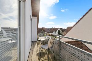 balcón con mesa y sillas en el techo en Apartments Münchbach - near Europa-Park and Rulantica - Parking I Kitchen I WiFi, en Rust