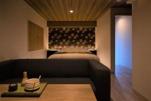 a living room with a couch and a bed at HOTEL ZEN-Adult Only in Hirosaki