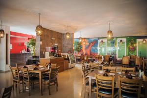 un restaurante con mesas y sillas y una cocina en Hotel Maioris La Paz en La Paz