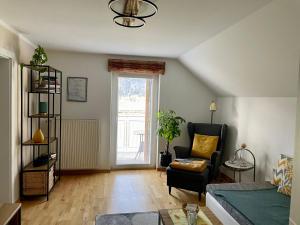 salon z kanapą, krzesłem i oknem w obiekcie Mountainview Apartment Scheurer w mieście Jenig