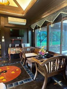 a living room with a wooden table and chairs at Bantunglom Resort in Mae Rim