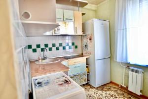 een kleine keuken met een wastafel en een koelkast bij В центре Павлодара светлая квартира in Pavlodar