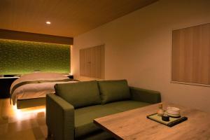 a living room with a couch and a bed at HOTEL ZEN-Adult Only in Hirosaki
