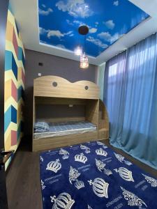Коттедж Чок-Тал Цо Париж 2 في Chok-Tal: غرفة نوم مع سرير بطابقين وسقف ازرق