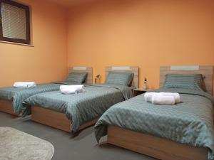 a bedroom with three beds with towels on them at BOGO Apartment in Bitola