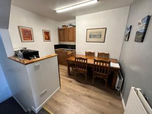 a kitchen and dining room with a table and a refrigerator at Belfast Duplex Apartment Siren Stays in Belfast