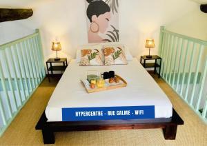 a white bed with a tray of fruit on it at Uncourtsejour - Nîmes la Rome française in Nîmes +15 photos