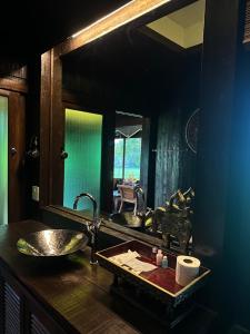 a bathroom with a sink and a large mirror at Bantunglom Resort in Mae Rim