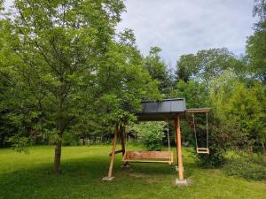 eine Schaukel in einem Park mit einem Baum in der Unterkunft Birtok Houses - Big house with 3 bedrooms in Borzont