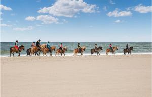 - un groupe de personnes à cheval sur la plage dans l'établissement Pet Friendly Home In Hanstholm With Kitchen, à Hanstholm