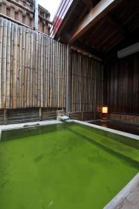 a pool of green water inside of a building at Kumanoyu Hotel in Yamanouchi