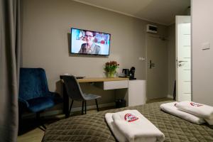 a hotel room with a bed and a desk and a tv at Kamienica no 111a in Warsaw