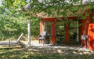 a porch of a house with a red door and a chair at Stunning Home In Aakirkeby With 3 Bedrooms And Wifi in Vester Sømarken