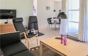 a living room with a couch and a table at Stunning Home In Aakirkeby With 3 Bedrooms And Wifi in Vester Sømarken
