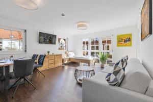 uma sala de estar com um sofá e uma mesa em Apartments Münchbach - near Europa-Park and Rulantica - Terrace I Parking I Kitchen I WiFi em Rust