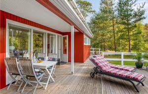 eine Veranda eines Hauses mit einem Tisch und Stühlen in der Unterkunft Lovely Home In Aakirkeby With Wifi in Vester Sømarken