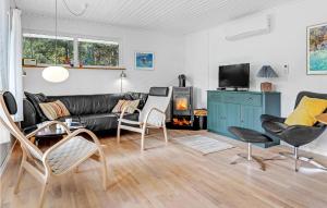uma sala de estar com um sofá de couro preto e cadeiras em Lovely Home In Aakirkeby With Wifi em Vester Sømarken
