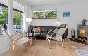 a living room with a couch and a table and chairs at Lovely Home In Aakirkeby With Wifi in Vester Sømarken