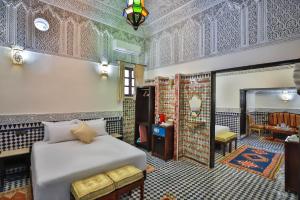 um quarto com uma cama e um espelho em Riad Farouzi Fes em Fez