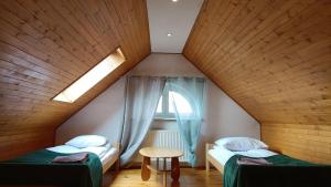 a attic room with two beds and a window at DOM WYPOCZYNKOWY RYBNICKA - Apartamenty in Gdynia