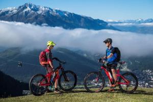 two men standing on a hill with their bikes at Alpineas in Leutasch