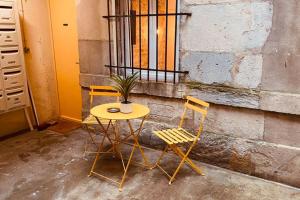 una mesa y dos sillas sentadas junto a un edificio en Studio rénové avec patio, coeur du centre ville en Besanzón