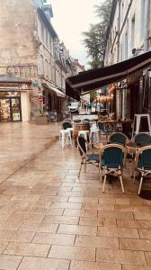 een lege straat met stoelen en tafels op een stoep bij Studio rénové avec patio, coeur du centre ville in Besançon