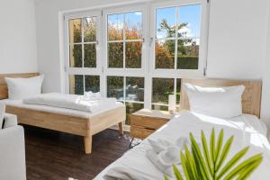 a bedroom with two beds and a large window at Apartments Münchbach - near Europa-Park and Rulantica - Terrace I Parking I Kitchen I WiFi in Rust