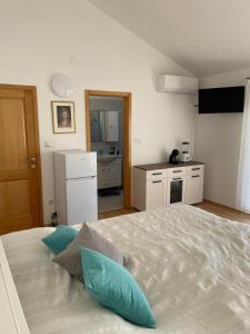 烏格連島的住宿－Apartman Tratica Ugljan，卧室配有带蓝色枕头的大型白色床
