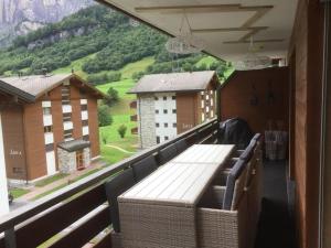 einen Balkon mit einem Tisch und Bergblick in der Unterkunft Magnifique appartement de montagne in Leukerbad