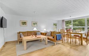 Stunning Home In Gistrup With Wifi في Gistrup: غرفة معيشة مع أريكة وطاولة وكراسي