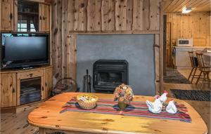 a living room with a table and a fireplace at Nice Home In Straumgjerde With Kitchen in Brunstad