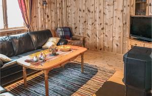 a living room with a couch and a coffee table at Nice Home In Straumgjerde With Kitchen in Brunstad