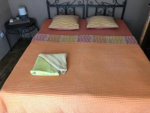 two beds with orange sheets and towels on them at Hostel Anton in Tivat