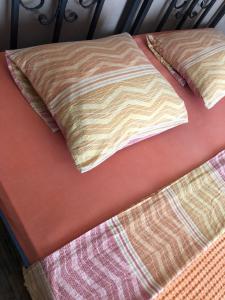 a bed with two pillows on top of it at Hostel Anton in Tivat