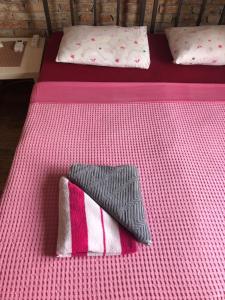 two beds with pink and white sheets and a blanket at Hostel Anton in Tivat