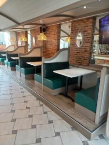 un comedor con mesas y sillas verdes en Hotel De La Mer en Saint-Malo