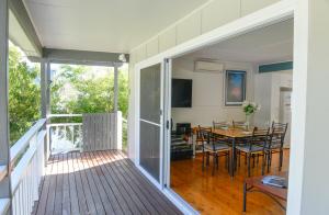 a living room with a table and a dining room at Paradise Bungalow Waterfront in Sanctuary Point