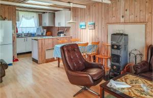 a living room with a leather chair and a kitchen at 3 Bedroom Lovely Home In Anholt in Anholt