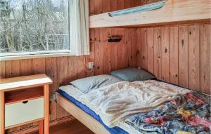 a bed in a wooden room with a window at 3 Bedroom Lovely Home In Anholt in Anholt