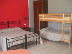 2 letti a castello in una camera con pareti rosse di Hotel Rifugio Alantino a Casamaina