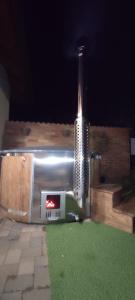 una parrilla en un patio por la noche con hierba en Golden Apartman, en Orosháza