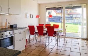 グドイェムにあるBeautiful Apartment In Gudhjem With House Sea Viewのキッチン(テーブル、赤い椅子付)