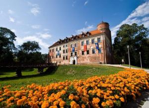 Un edificio con un ramo de flores delante. en Złote Krany Apartament Termalny, en Uniejów
